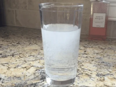 Glass of water with a cloudy upper layer and clearer water below
