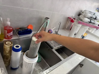 Technician replacing used cartridges in an Aqua Cares water filtration system